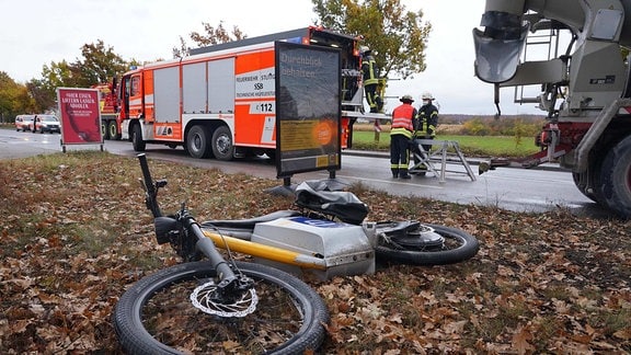 Ein E-Bike liegt nach einem Unfall mit einem Lkw an einer Straße