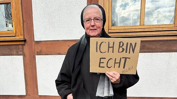 Nonne bei Faschingsumzug mit Schild "Ich bin echt"