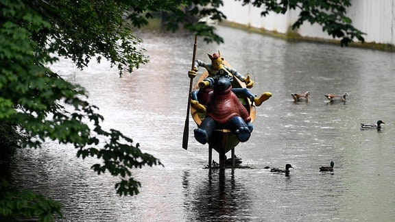 Enten schwimmen um die Figuren von Käpt'n Blaubär und Hein Blöd in der Erfurter Gera.