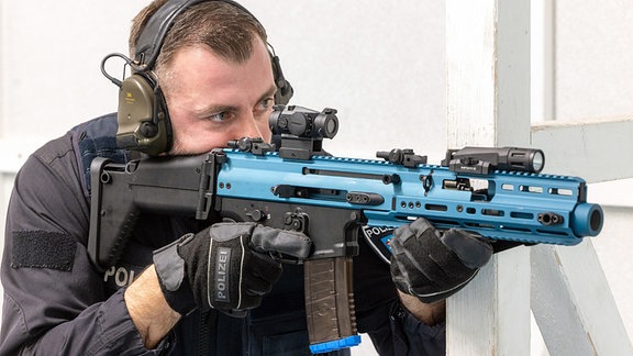 Ein Polizist hält bei einer Übung im Bildungszentrum der Thüringer Polizei eine blau markierte Übungsversion der Waffe „FN Herstal Scar-SC“ im Anschlag.