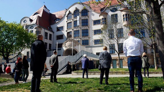 Menschen stehen vor Gutenberg-Gymnasium in Erfurt