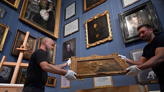 Oliver Friedmann (l) und Christian Kümpfel, Depotmitarbeiter, stellen die Ölskizze «Der Heilige Gregorius von Nazianz» von Peter Paul Rubens aus dem Jahr 1621 im Herzoglichen Museum der Friedenstein Stiftung Gotha auf.