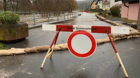 Eine von Wasser überflutete Straße, davor ein Durchfahrt-verboten-Schild