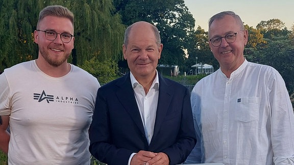 Stephan (re.) und Markus Baldßun (li.) machen ein Foto mit Bundeskanzler Olaf Scholz.