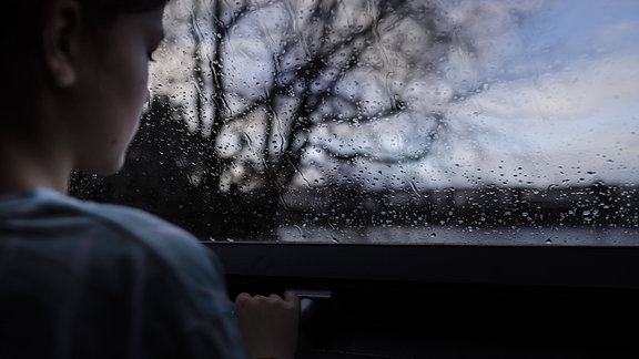Mädchen schaut aus einem Fenster 