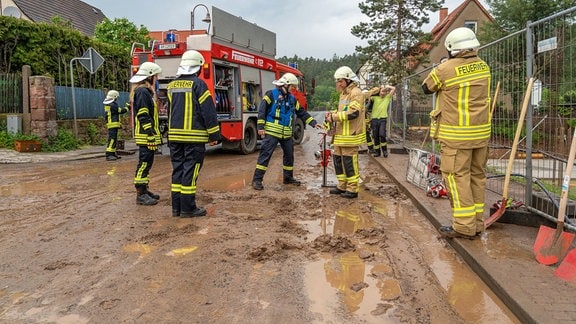 Feuerwehr auf einer schlammigen Straße in Kranichfeld.