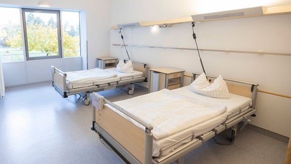 Leere Krankenhausbetten in einem Raum.