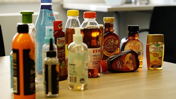 Plastikflaschen mit Getränken, Flüssigseife, Schuhcreme, Sirup und Honig