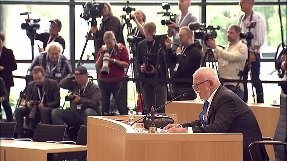 Alterspräsidenten Treutler von der AfD spricht nach der vierten Unterbrechung im Landtag. Im Hintergrund stehen Fotografen.