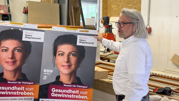 Tischler Jens Zöllner mit Plakaten von Sarah Wagenknecht (BSW)
