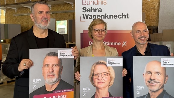 Die Spitzenkandidatin des Bündnis Sarah Wagenknecht (BSW) Katja Wolf, ihr Co-Spitzenkandidat Steffen Schütz und Listenkandidat Steffen Quasebarth, hinter ihren Plakaten posierend