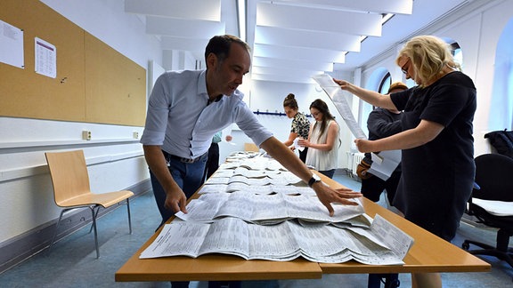 Wahlhelfer sortieren die Stimmzettel der Stichwahl und der Europawahl in einem Wahllokal in der Landeshauptstadt Thüringen. 