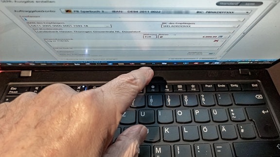 Ein Mann  erledigt seine Bankgeschäfte mit einer Banking-Software am Laptop. 