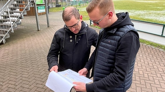 Max Knabe und Christian Schneider, Vorstand Grün Weiß, blättern in Plänen
