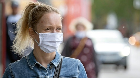 Eine Frau mit Behelfs- Mund und Nasenmaske in der Innenstadt von Jena. 