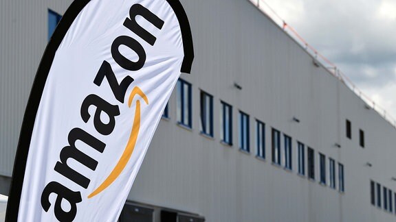Ein Amazon-Banner weht vor dem zukünftigen Amazon Verteilzentrum, das im Herbst 2019 seinen Betrieb aufnehmen soll. Damit wird das bestehende Logistiknetzwerk um ein Verteilzentrum erweitert.