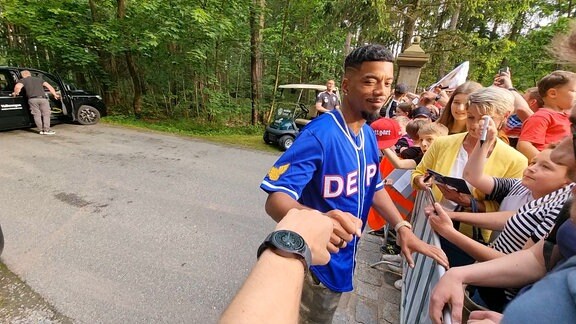 Fußball-Spieler Benjamin Henrichs gibt jemandem einen Faust-Check