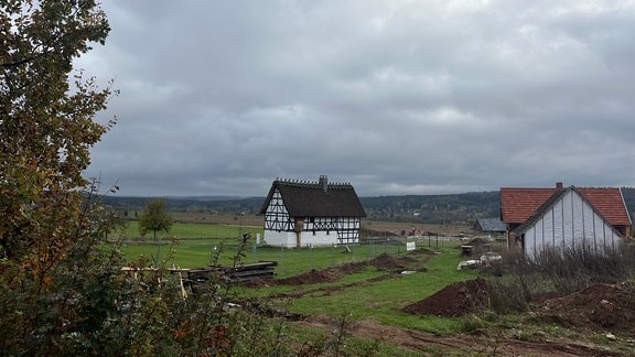 Ein Blick in das historische Dorf des Freilichtmuseums in Hohenfelden. Zwei alte Fachwerkhäuser stehen in einer ländlichen Idylle.