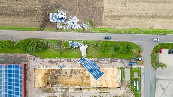 Eine zerstörte Photovoltaikanlage auf einem Feld verstreut nach einem Unwetter