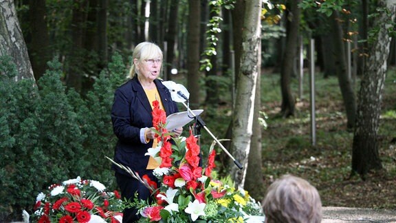 Gedenkfeier zum Jahrestag der Errichtung des Speziallagers Nr. 2 in Buchenwald. Der Trauerplatz mit einem großen Kreuz. Metallstelen im Wald markieren die Massengräber. 