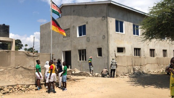 Schülerinnen einer Schule in Mombasa in Kenia hissen Flaggen.