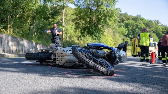 Ein kaputtes Motorrad liegt auf der Straße.