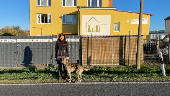 Maria Weihrauch und Motte vor einem gelben Gebäude