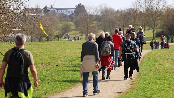 Menschen laufen einen Weg entlang.