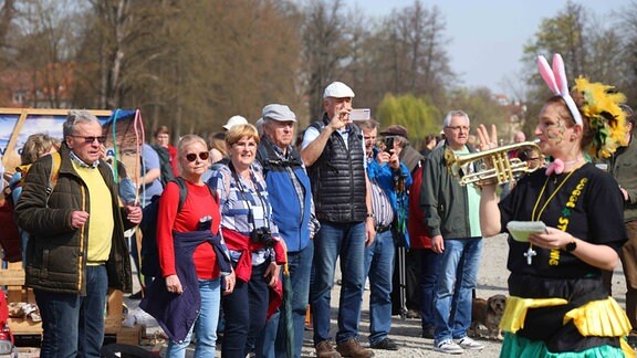 Menschen stehen in der Sonne.