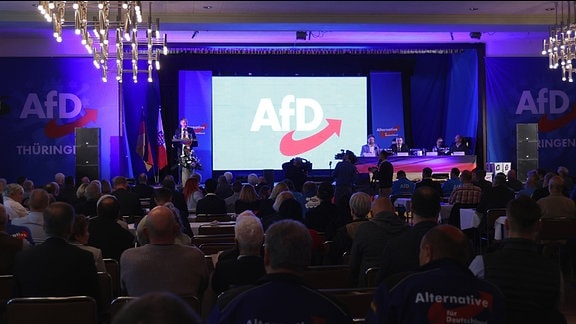 Delegierte sitzen im Saal und hören dem AfD-Landesvorsitzenden Björn Höcke zu, der eine Rede hält.