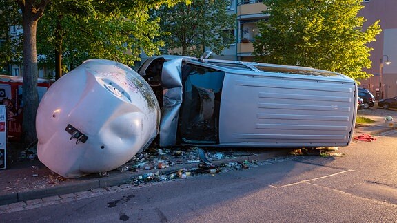 Ein Kleintransporter liegt auf der Seite, nachdem er bei einem Unfall in Kranichfeld gegen Glascontainer gefahren war
