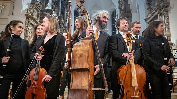 Musiker mit Blas- und Streichinstrumenten in einer Kirche