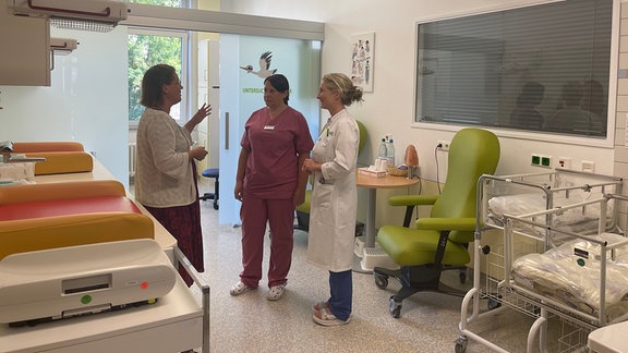 Drei Frauen stehen in einem Klinikzimmer