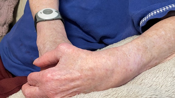Notrufknopf am Arm einer alten Frau