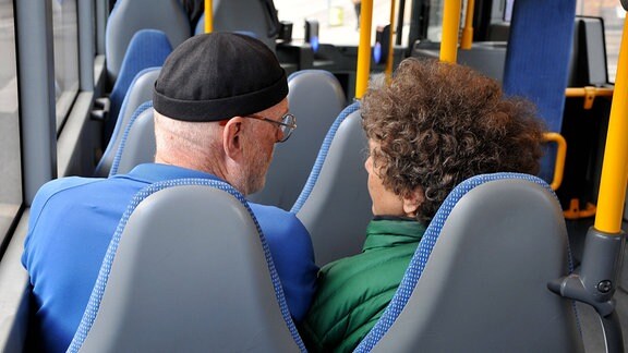 Ein Mann und eine Frau sitzen nebeneinander in einem Bus.