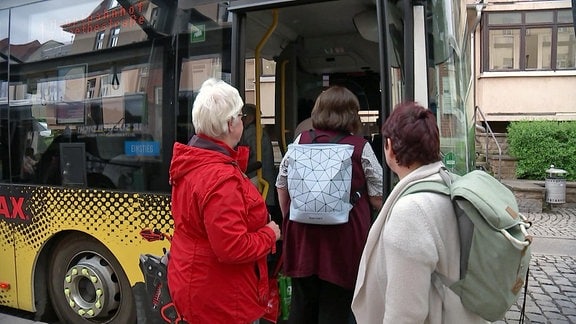 Frauen steigen in einen Bus ein