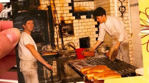 Ein altes Foto zeigt zwei Bäcker in einer Backstube.