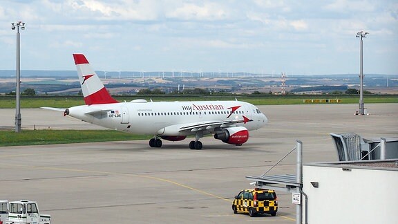 ine rot-weiß lackierte Maschine der Austrian Airlines auf dem Vorfeld des Flughafens Erfurt