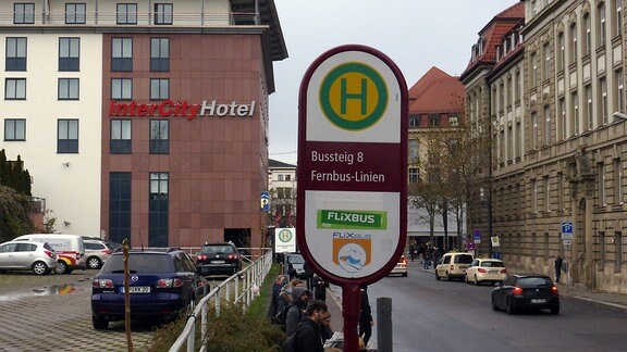Ein Bushaltestellenschild der Erfurter Fernbus-Haltestelle in der Kurt-Schumacher-Straße, im Hintergrund ist das InterCity-Hotel