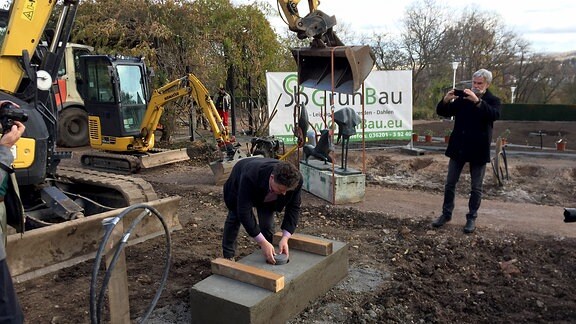 Egapark-Betriebsleiter Chris Lange versenkt eine Zeitkapsel bei Bauarbeiten im Rosengarten