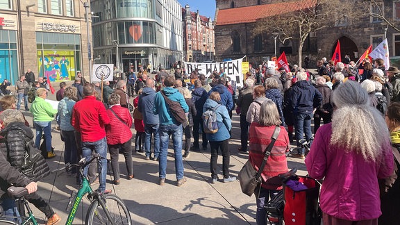 Teilnehmer einer Friedenskundgebung mit Transparenten und Linke-Fahnen bei Ostermarsch