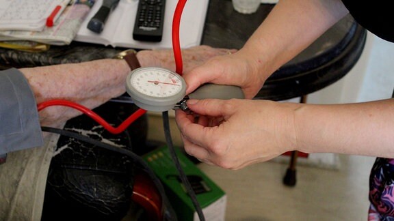 Eine Frau hält einen Blutdruckmesser.
