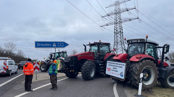 Bauern blockieren eine Autobahnzufahrt.