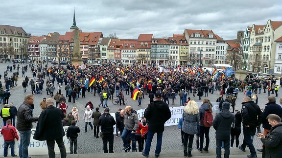 Auf einem Platz steht eine große Zahl von Menschen bei einer Kundgebung