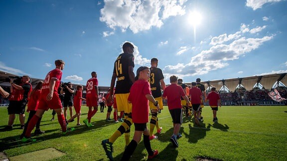 Die Teams von Rot-Weiß Erfurt und Borussia Dortmund betreten zusammen mit den Einlaufkindern den Platz.