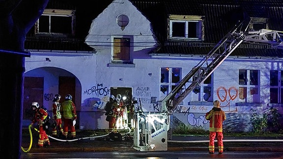 Feuerwehrleute an einem brennenden Haus im Einsatz