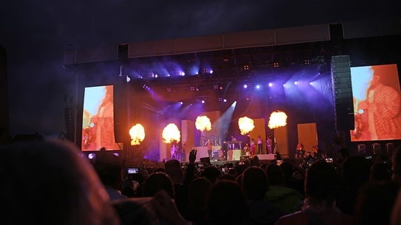 Flammen einer Pyro-Show auf der Bühne.