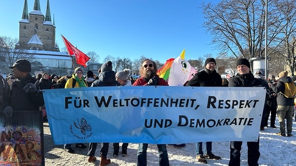 Demonstranten stehen auf dem Domplatz in Erfurt. Ein Mann hält ein Schild: Für "Weltoffenheit und Demokratie".