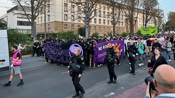 Zahlreiche Menschen mit Plakaten laufen in Erfurt am Thüringer Landtag vorbei.