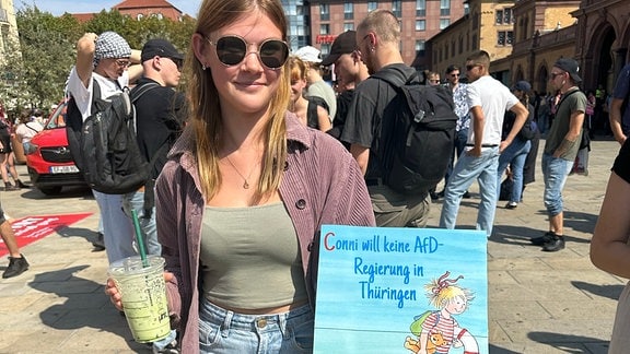 Junge Frau bei Demonstration gegen AfD mit Plakat, auf dem "Conni will keine AfD-Regierung in Thüringen" steht.